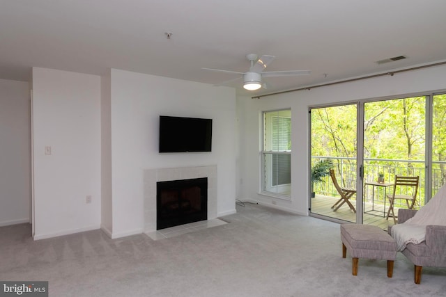 living room with a fireplace, ceiling fan, carpet, and visible vents