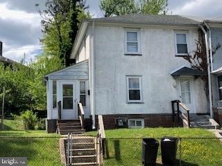 910 E 15th St, Chester, PA 19013 - view of front of property with a gate, a front lawn, a fenced front yard, and stucco siding
