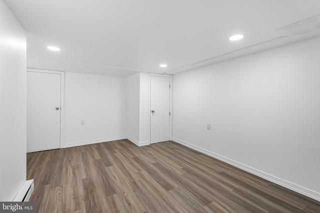 finished below grade area with baseboards, recessed lighting, and wood finished floors