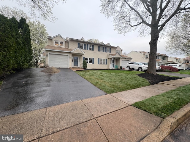 view of front of property featuring a garage, a front lawn, and driveway