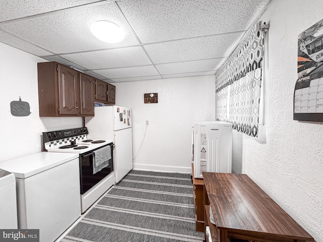 kitchen with dark brown cabinetry, white appliances, light countertops, carpet flooring, and a paneled ceiling