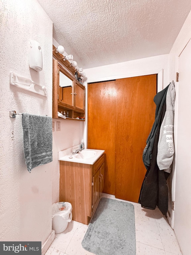 bathroom with a textured ceiling and vanity