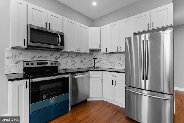 5210 Arch St, Philadelphia, PA 19139 - kitchen featuring dark wood-style floors, a sink, stainless steel appliances, decorative backsplash, and dark countertops