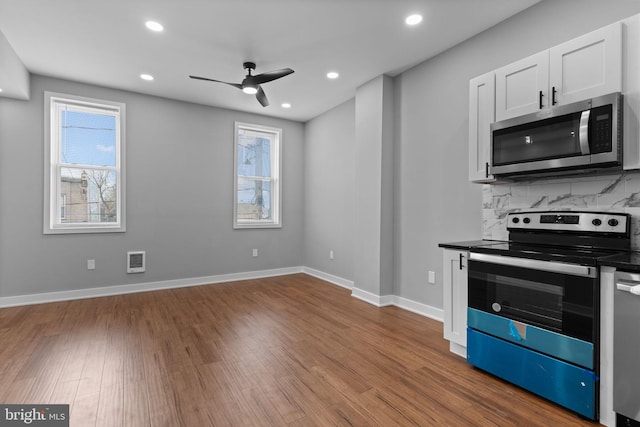 5210 Arch St, Philadelphia, PA 19139 - kitchen featuring tasteful backsplash, dark countertops, stainless steel appliances, dark wood-type flooring, and a ceiling fan