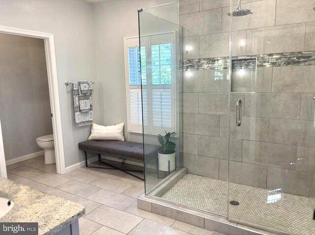 full bath with a shower stall, toilet, and tile patterned flooring