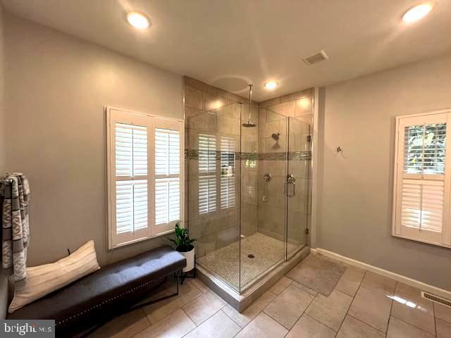 bathroom with recessed lighting, a stall shower, tile patterned floors, and baseboards