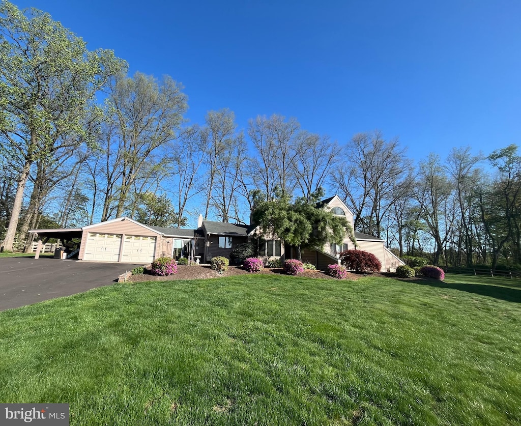 view of front of house with a front lawn, driveway, a garage, and a carport