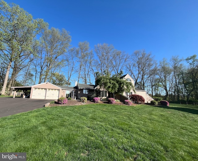 view of front of house with a front lawn, driveway, a garage, and a carport