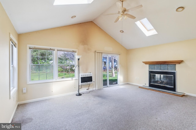 unfurnished living room featuring heating unit, a ceiling fan, high vaulted ceiling, a skylight, and a glass covered fireplace