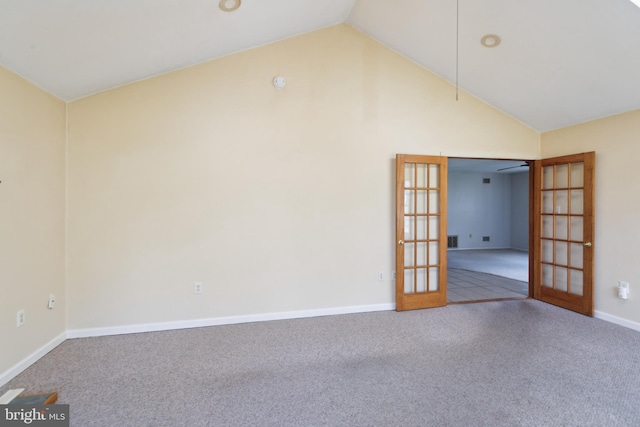 carpeted spare room featuring high vaulted ceiling, baseboards, and french doors