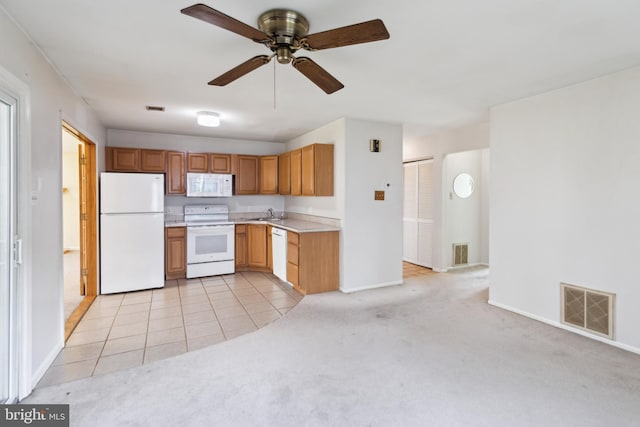 kitchen with white appliances, light countertops, visible vents, and light colored carpet