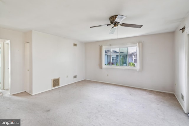 carpeted spare room featuring a ceiling fan, baseboards, and visible vents