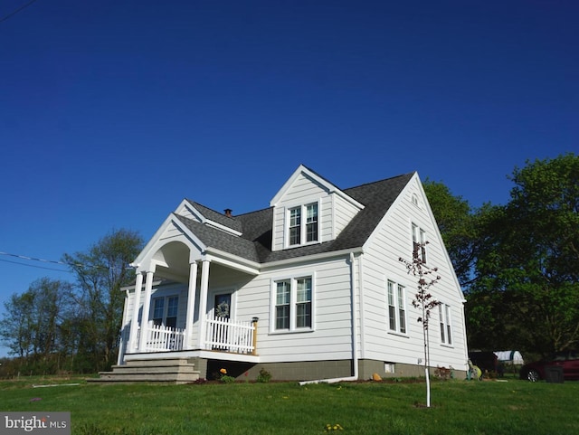 view of front of property featuring a shingled roof, a porch, and a front lawn