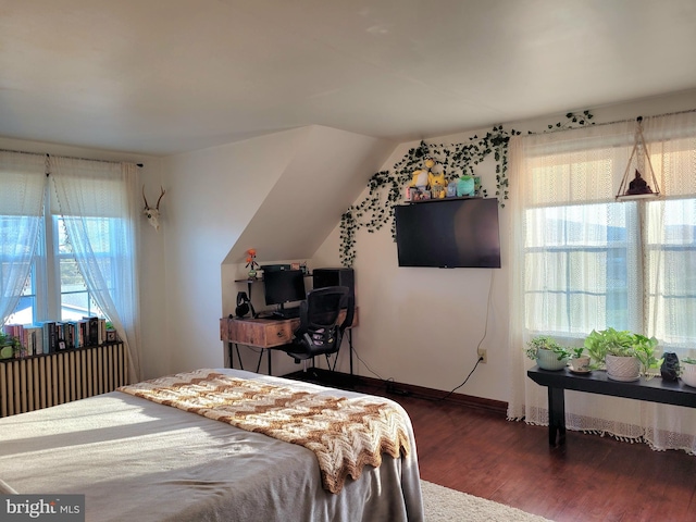 bedroom featuring baseboards, vaulted ceiling, and wood finished floors