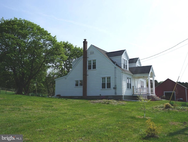 rear view of house featuring a lawn and a chimney
