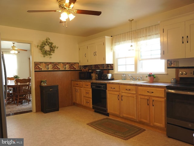 kitchen featuring stainless steel range with electric stovetop, wainscoting, ceiling fan, black dishwasher, and a sink