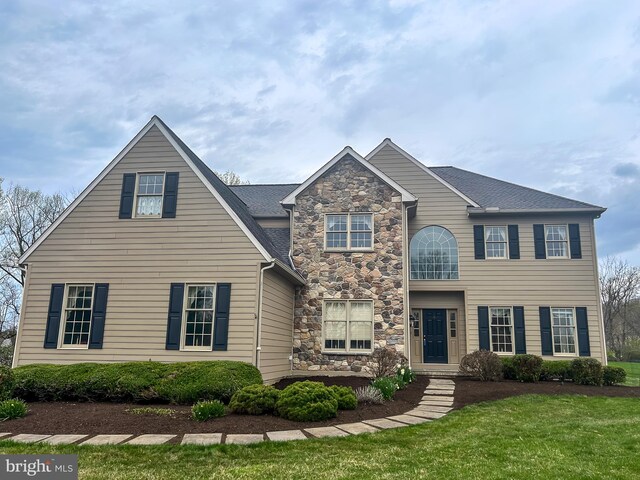 view of front of home with a front yard and stone siding