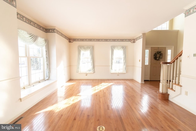 entrance foyer featuring baseboards, hardwood / wood-style flooring, and stairs