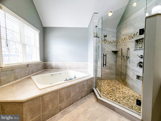 bathroom with a bath, a stall shower, tile patterned flooring, and lofted ceiling
