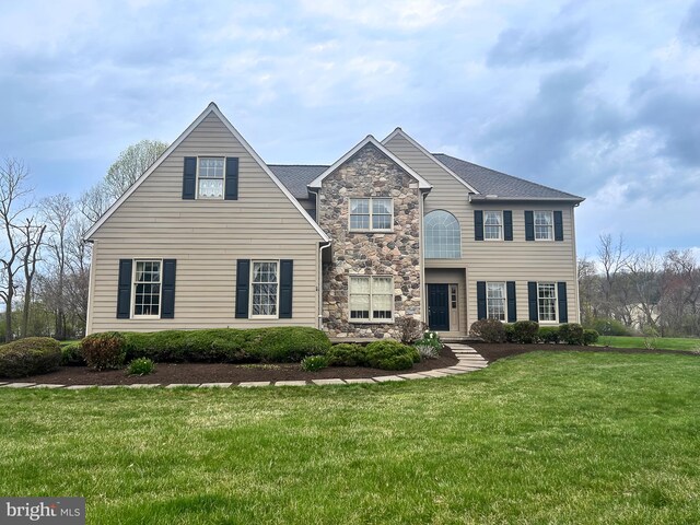 view of front facade with a front lawn and stone siding