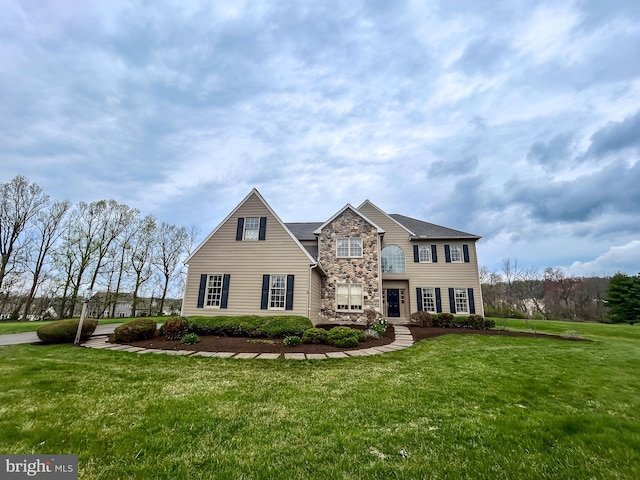 view of front facade with a front yard and stone siding
