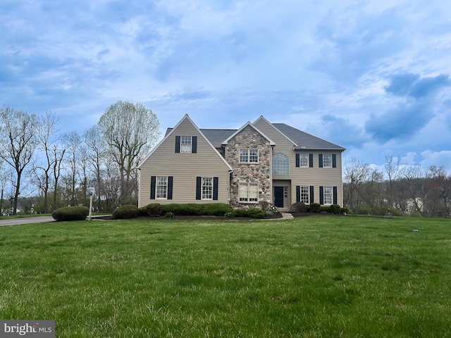 traditional home featuring a front yard and stone siding