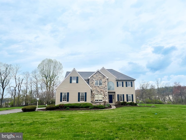 view of front facade with a front yard and stone siding