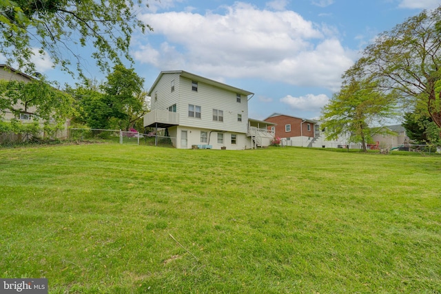 back of house with fence and a yard