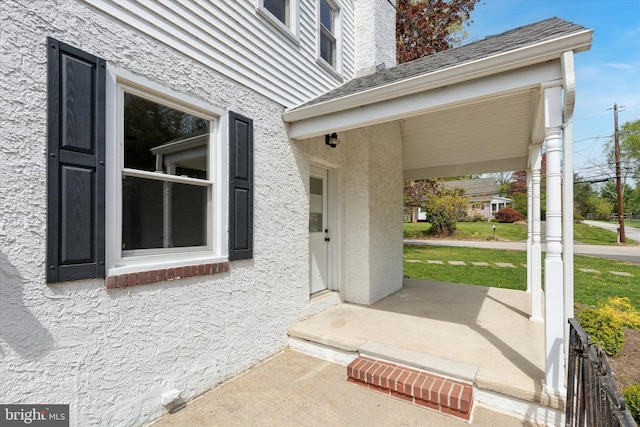 entrance to property with stucco siding and covered porch