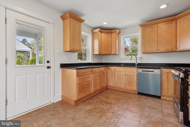 kitchen featuring dark countertops, stainless steel appliances, recessed lighting, and a sink