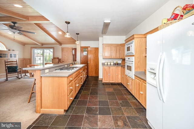 kitchen featuring wooden ceiling, white appliances, a breakfast bar area, ceiling fan, and a sink