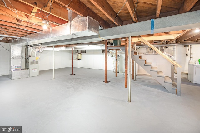 unfinished below grade area with heating unit, stairway, and washer / clothes dryer