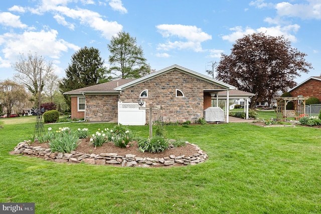 view of property exterior with a yard, stone siding, and fence