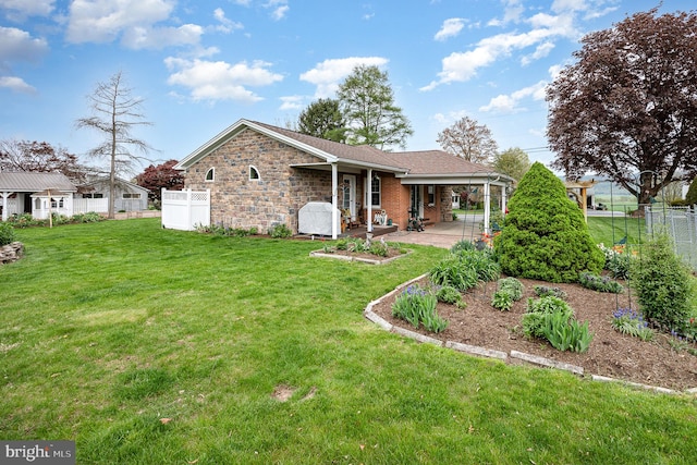 rear view of property featuring an attached carport, fence, a yard, and a patio area