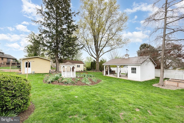 view of yard featuring an outdoor structure, a patio, and fence