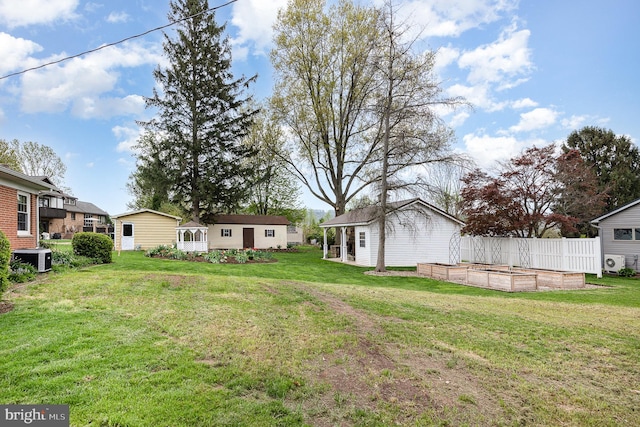 view of yard featuring central air condition unit, an outdoor structure, fence, and a vegetable garden
