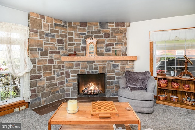 carpeted living room with a stone fireplace