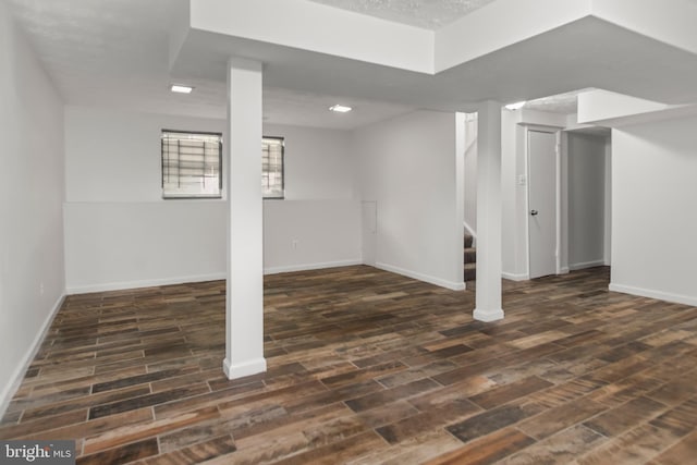 below grade area featuring stairs, baseboards, and wood finished floors