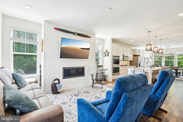 1579 Meadowlark Glen Rd, Dumfries, VA 22026 - living room with recessed lighting, baseboards, a glass covered fireplace, and light wood-style flooring