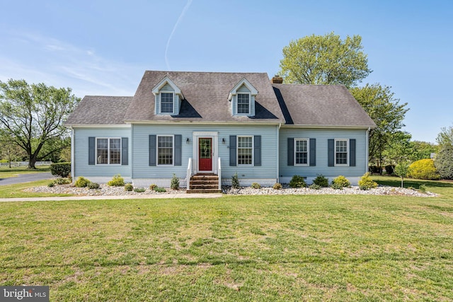 cape cod home with a chimney, a shingled roof, and a front lawn