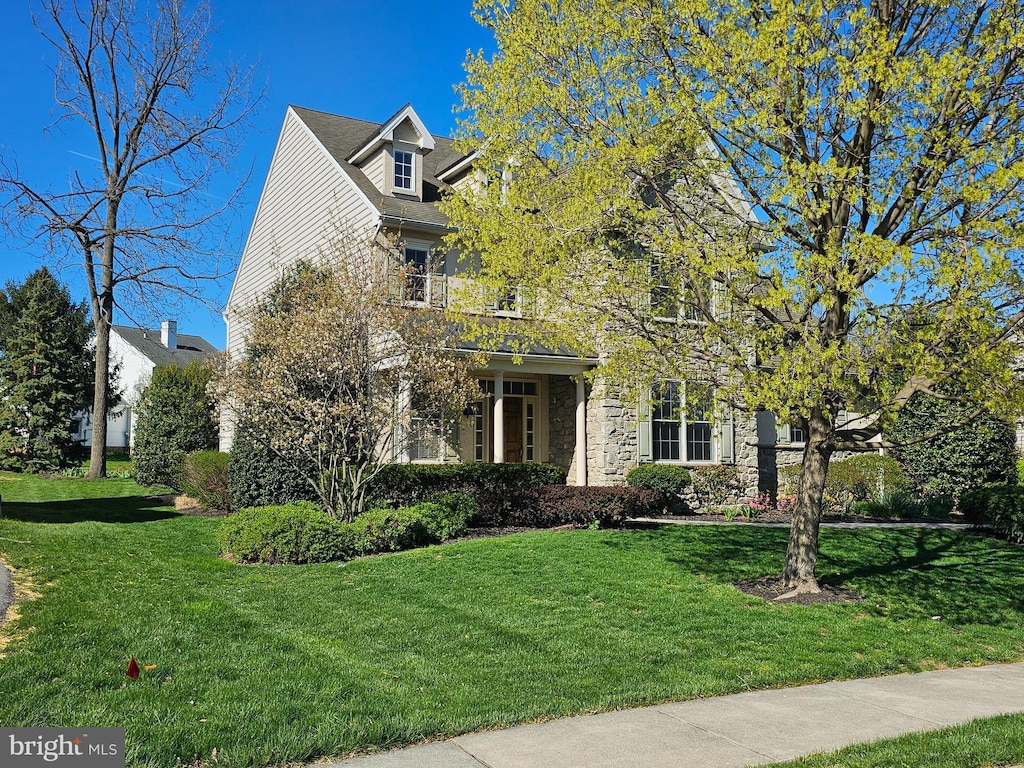 view of front of property featuring a front lawn and stone siding