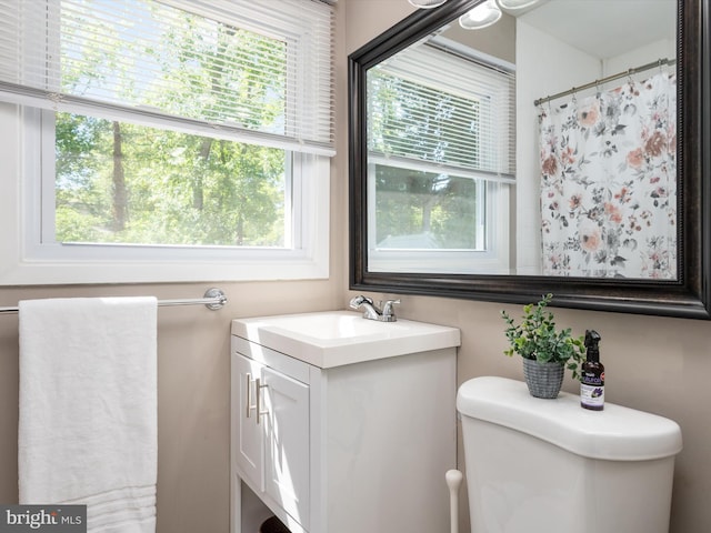 bathroom featuring vanity, toilet, and curtained shower