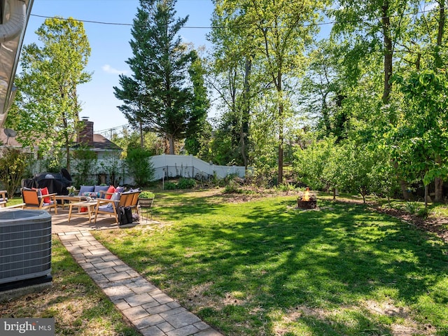 view of yard featuring a patio, central AC unit, an outdoor living space with a fire pit, and a fenced backyard