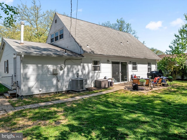 back of property featuring a lawn, a patio, a shingled roof, and central AC unit