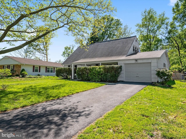 single story home with a garage, a front lawn, and aphalt driveway