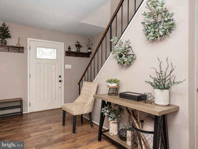 entryway with baseboards, wood finished floors, and stairway