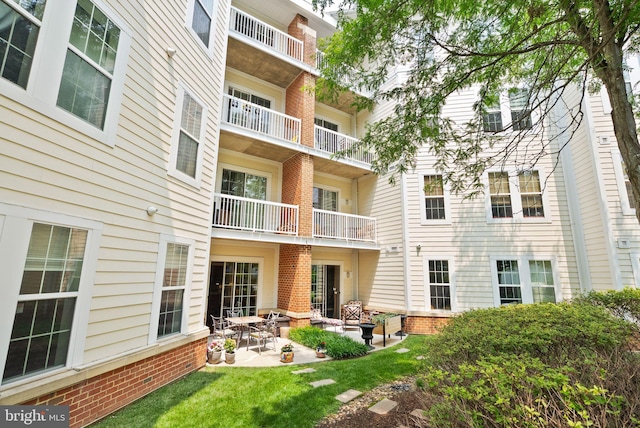 400 Cameron Station Blvd Unit 105, Alexandria, VA 22304 - rear view of property featuring brick siding, a patio area, and a yard