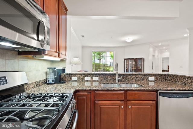 400 Cameron Station Blvd Unit 105, Alexandria, VA 22304 - kitchen featuring stainless steel appliances, a sink, dark stone countertops, backsplash, and brown cabinets