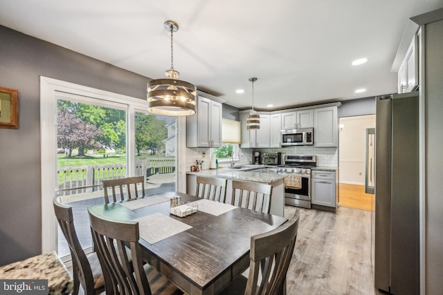 dining room with recessed lighting, light wood finished floors, and a toaster
