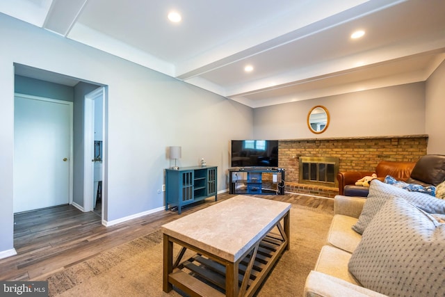 living room with a fireplace, beam ceiling, wood finished floors, baseboards, and recessed lighting